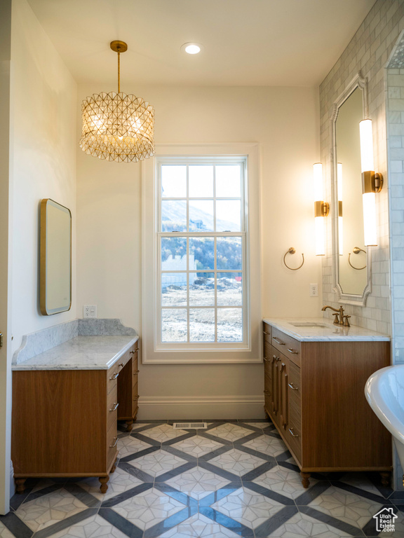 Bathroom with vanity, tile patterned flooring, and a notable chandelier