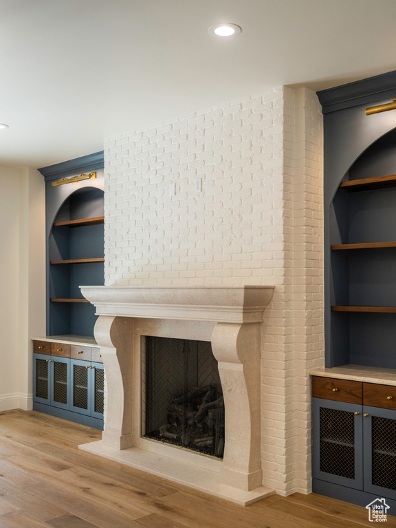 Room details featuring a fireplace, wood-type flooring, and built in features