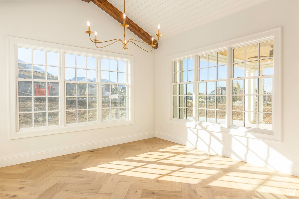 Unfurnished dining area featuring an inviting chandelier, wood ceiling, light parquet floors, vaulted ceiling with beams, and a mountain view