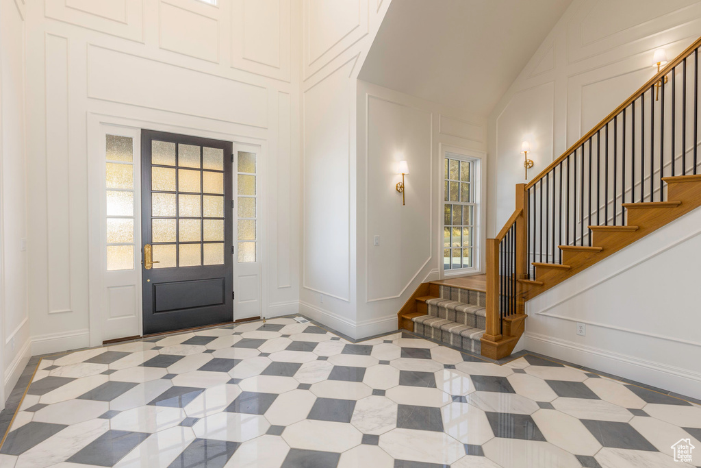 Foyer entrance featuring high vaulted ceiling and plenty of natural light