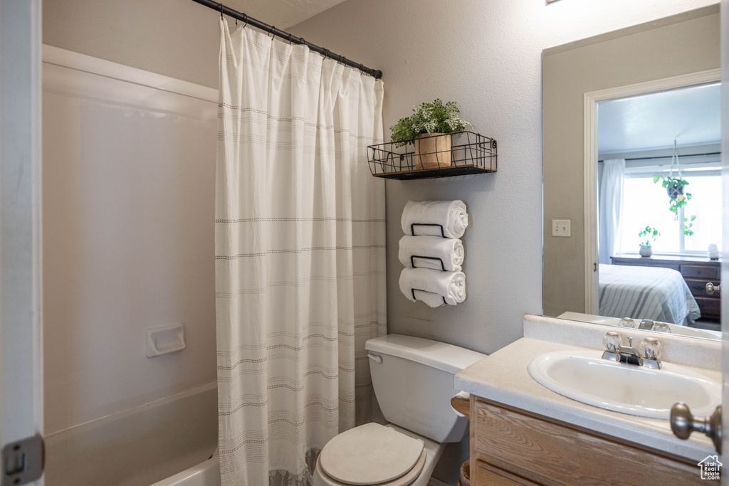 Full bathroom featuring shower / bath combo, vanity, and toilet