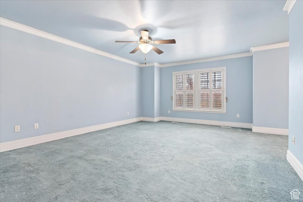 Spare room featuring ceiling fan, carpet floors, and crown molding