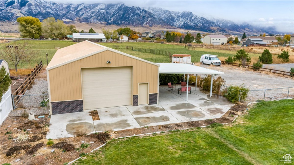 Garage with a mountain view and a yard