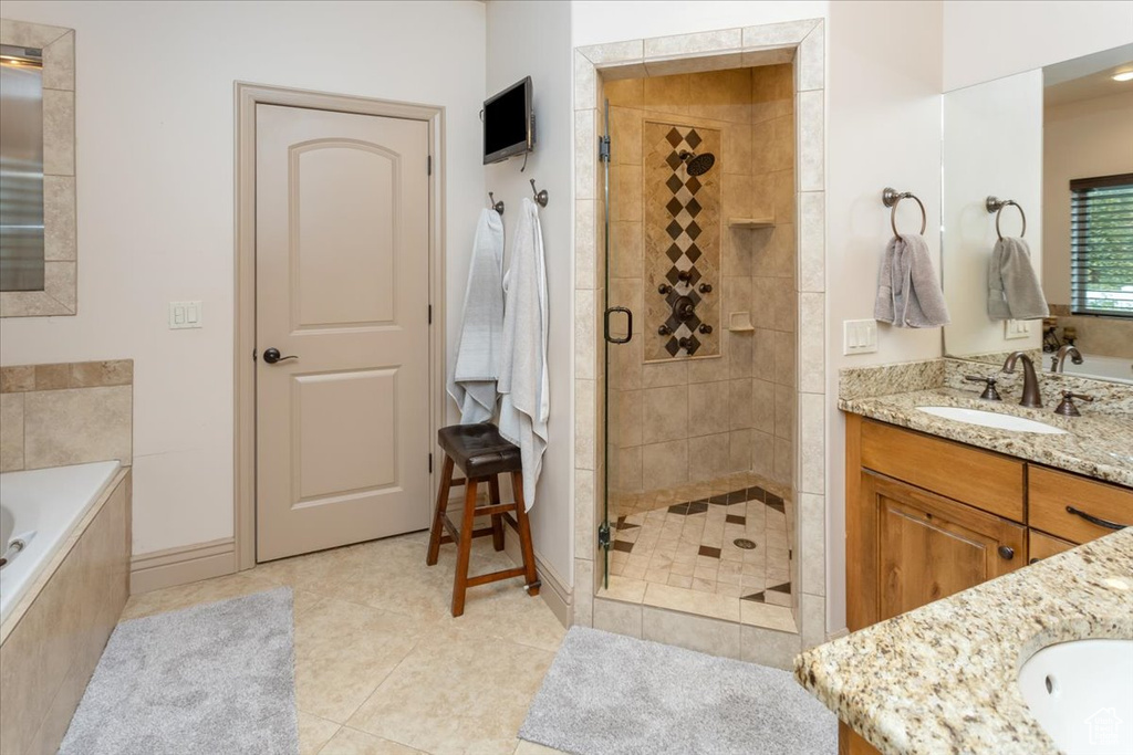 Bathroom with vanity, tile patterned floors, and shower with separate bathtub