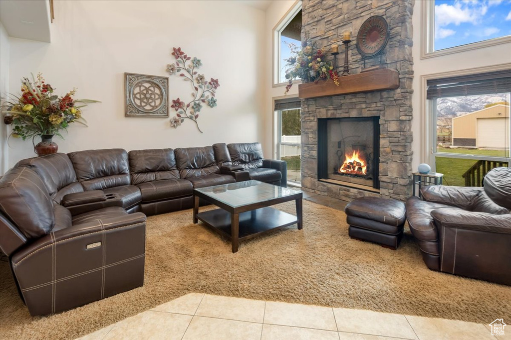 Tiled living room with a stone fireplace and a towering ceiling