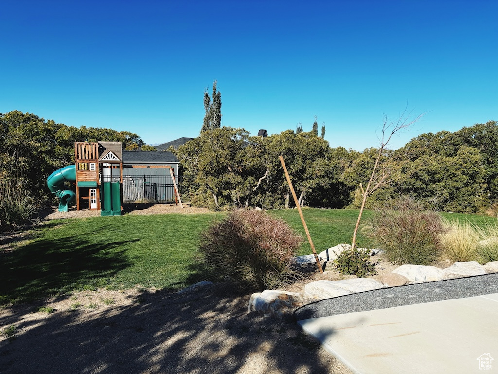 View of grassy yard featuring a playground