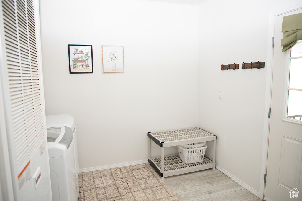 Laundry area featuring light wood-type flooring and independent washer and dryer