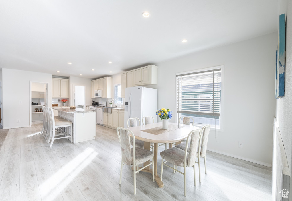 Dining space with sink and light wood-type flooring