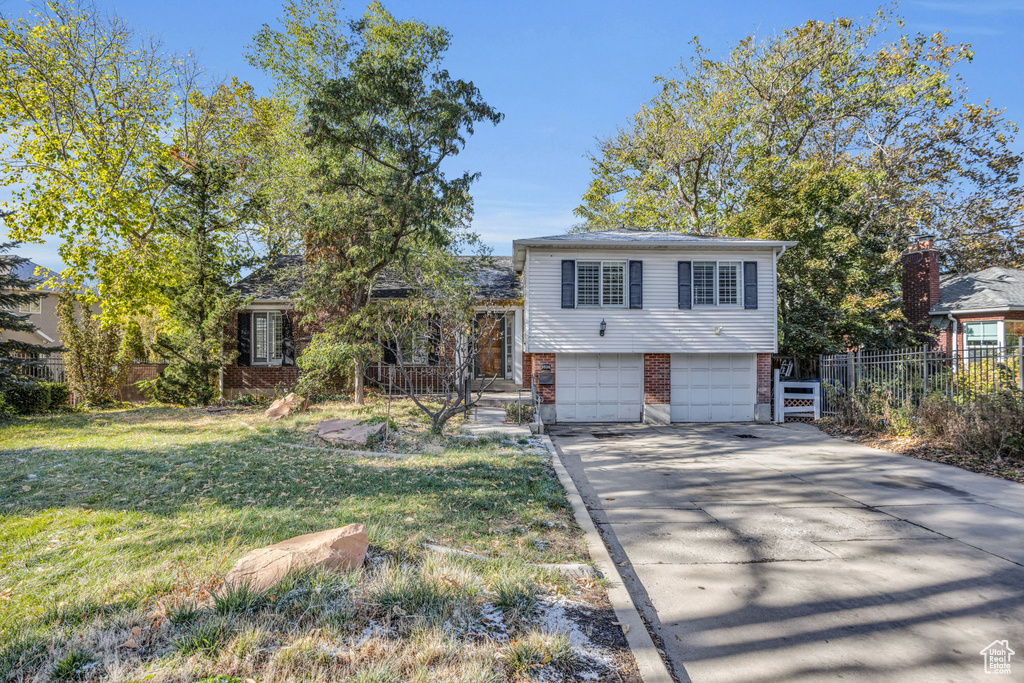 View of front of house featuring a garage and a front lawn