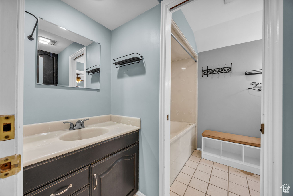 Bathroom featuring tile patterned flooring, vanity, and a tub