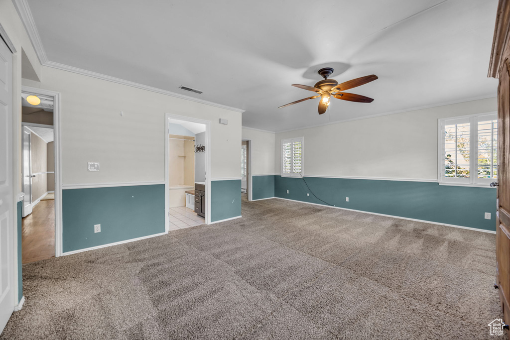 Spare room with ceiling fan, light carpet, and crown molding