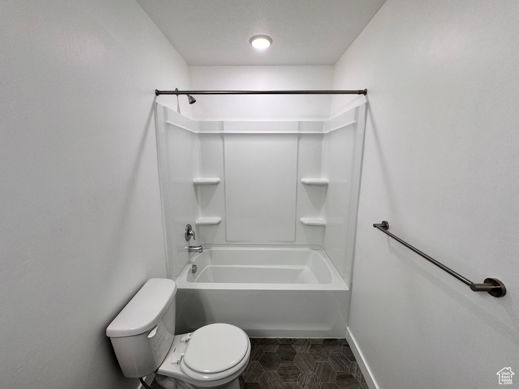 Full bathroom featuring baseboards, toilet, tile patterned flooring, and shower / bathtub combination