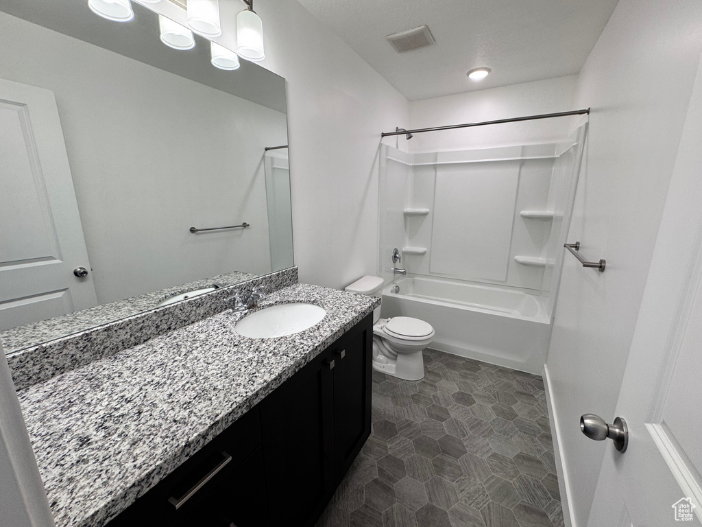 Bathroom featuring visible vents, baseboards, toilet, vanity, and bathing tub / shower combination