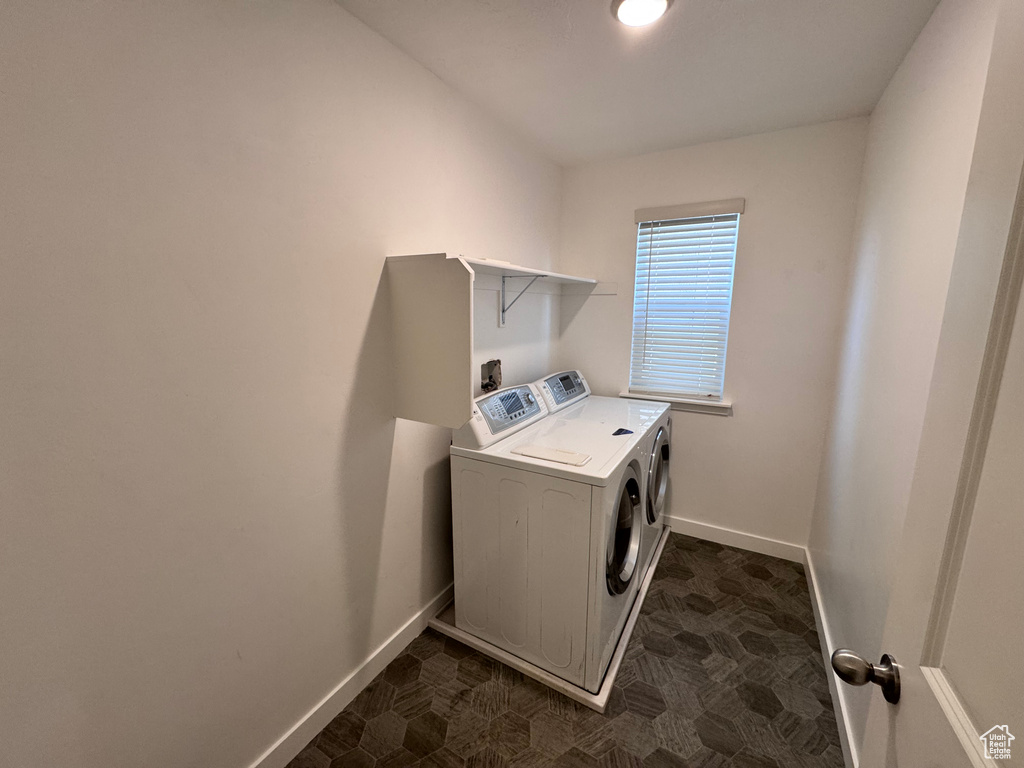 Washroom with baseboards, washing machine and dryer, and laundry area