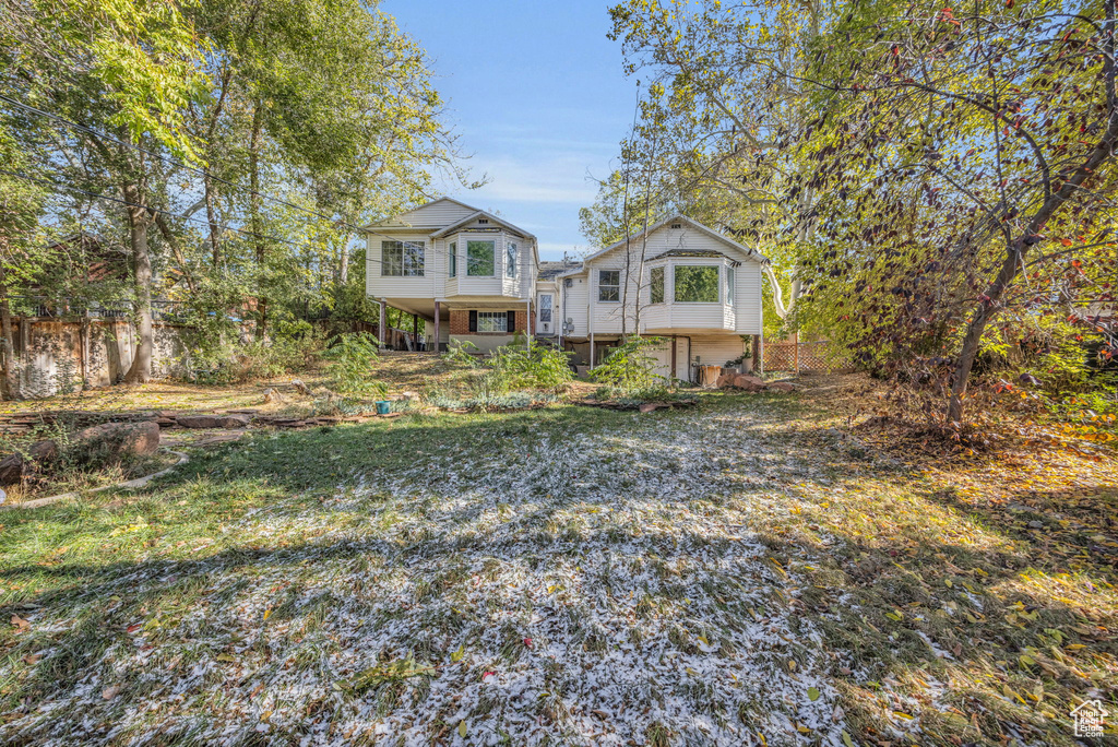 View of front of home featuring a front lawn and a balcony