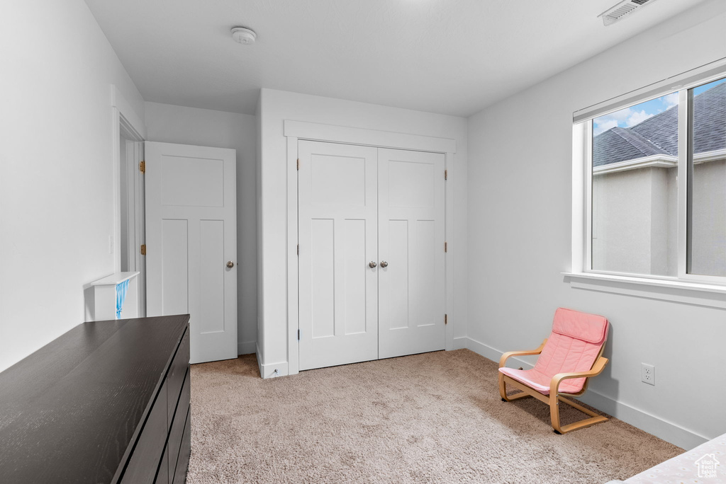 Unfurnished bedroom featuring light carpet and a closet