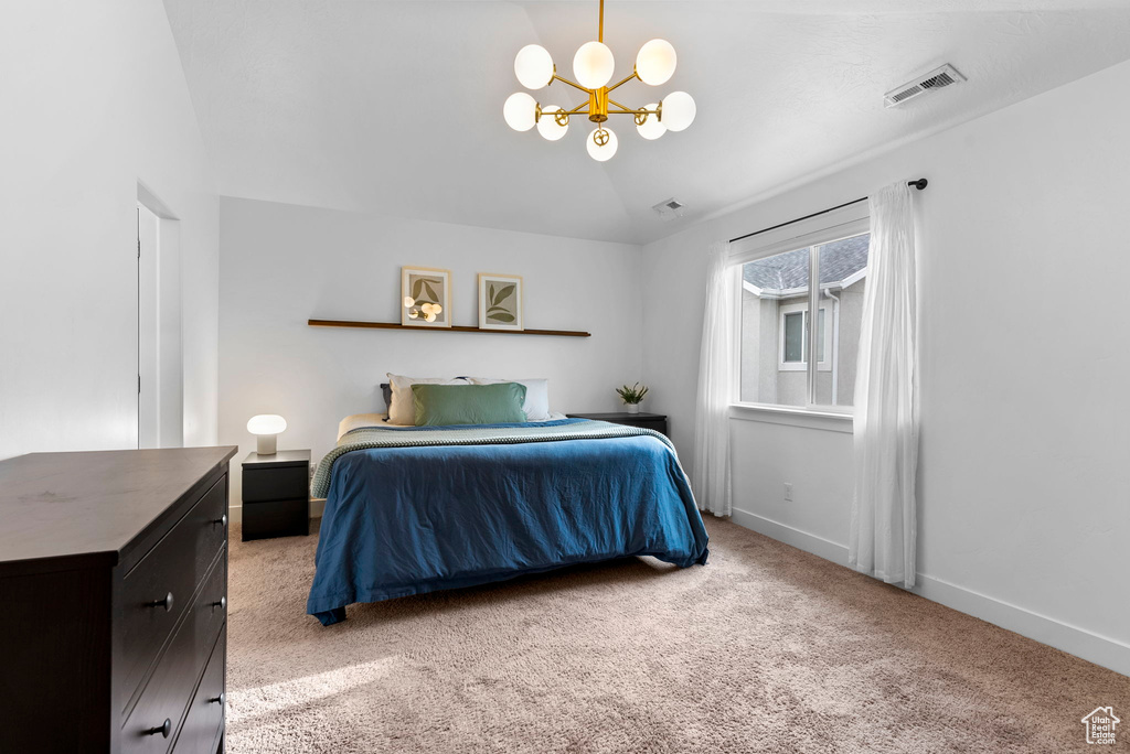 Carpeted bedroom featuring a notable chandelier