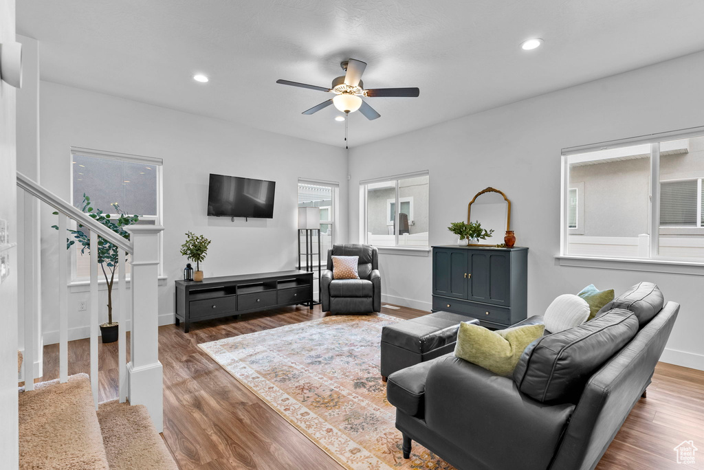 Living room with dark hardwood / wood-style flooring and ceiling fan