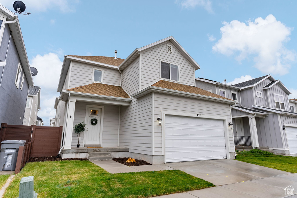 View of front of house with a garage and a front lawn