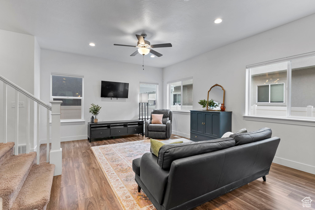 Living room featuring dark wood-type flooring and ceiling fan