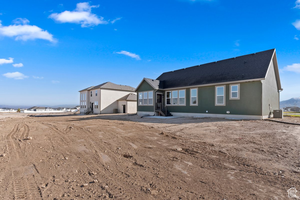 Rear view of property with cooling unit