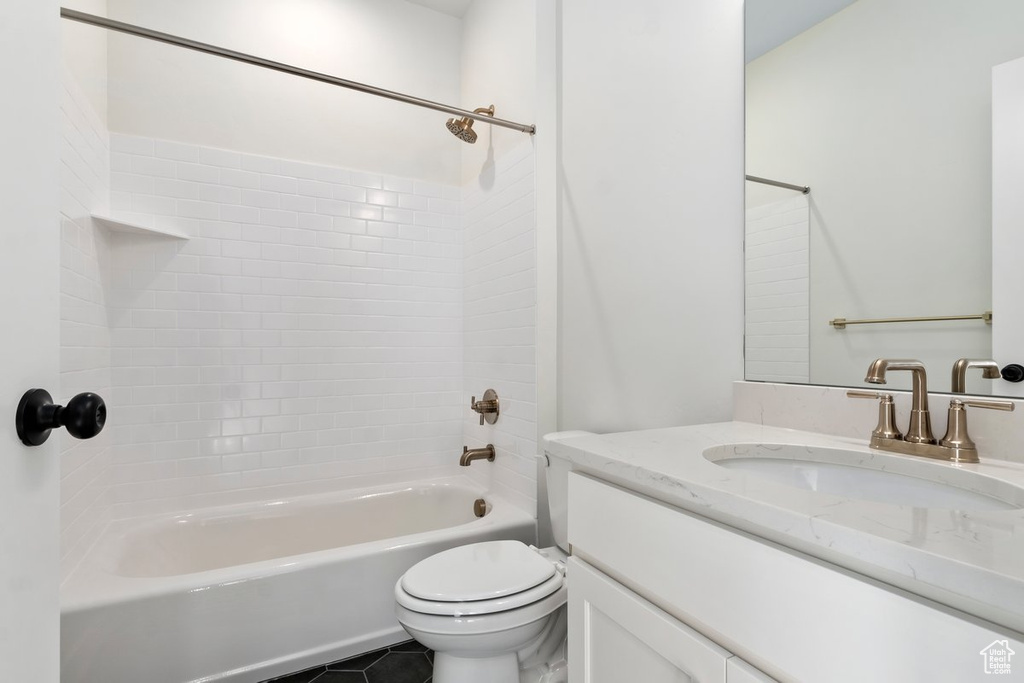 Full bathroom with tile patterned flooring, tiled shower / bath, toilet, and vanity