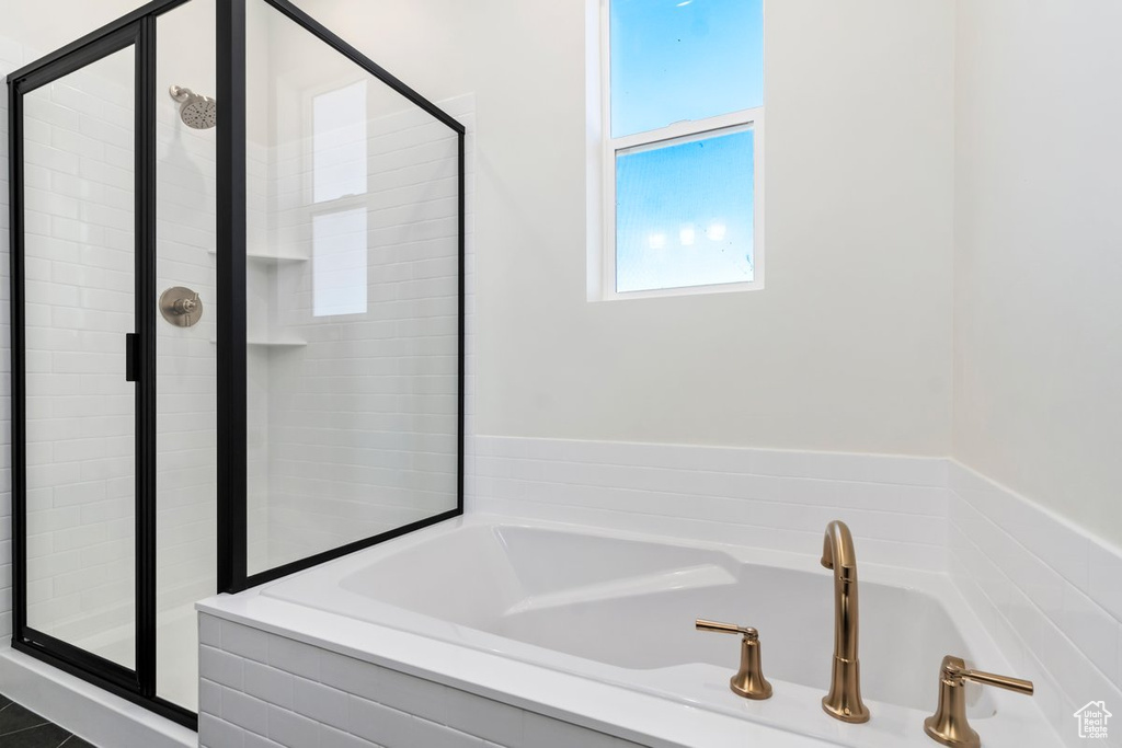 Bathroom featuring shower with separate bathtub