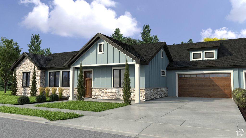View of front of home featuring stone siding, driveway, and board and batten siding