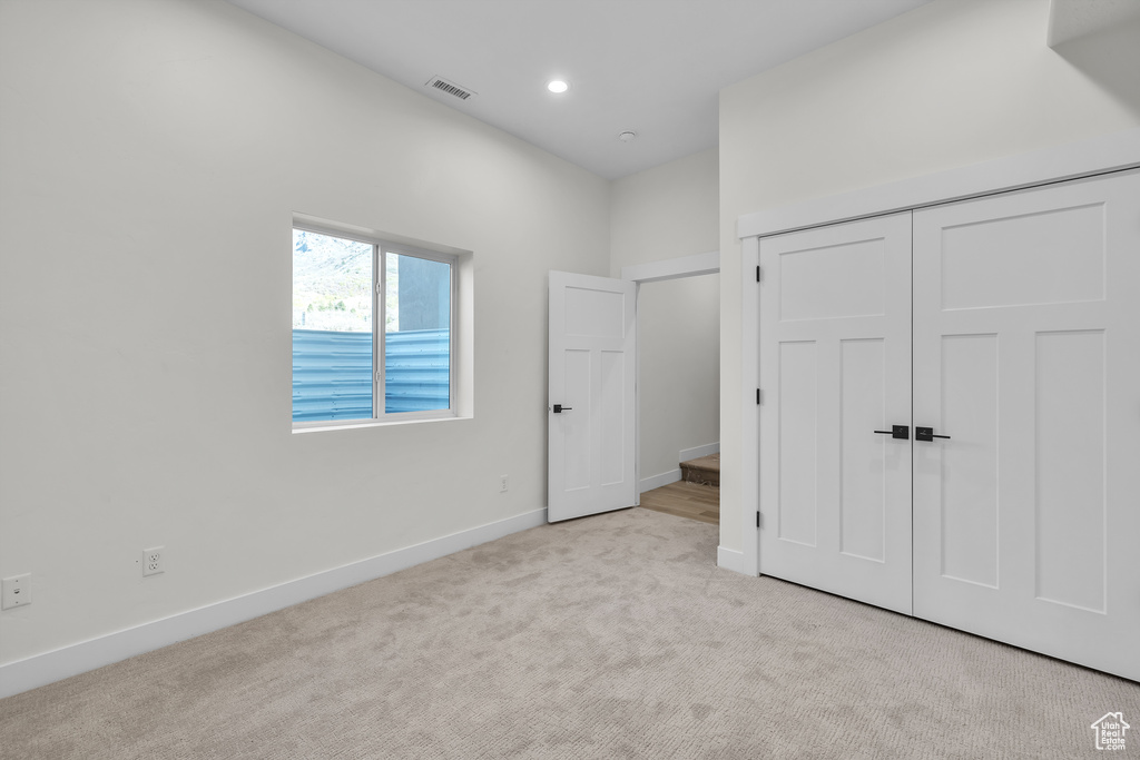 Unfurnished bedroom with a closet, carpet floors, baseboards, visible vents, and recessed lighting