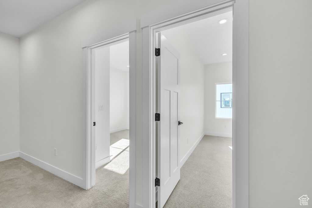Corridor featuring light carpet, baseboards, and recessed lighting