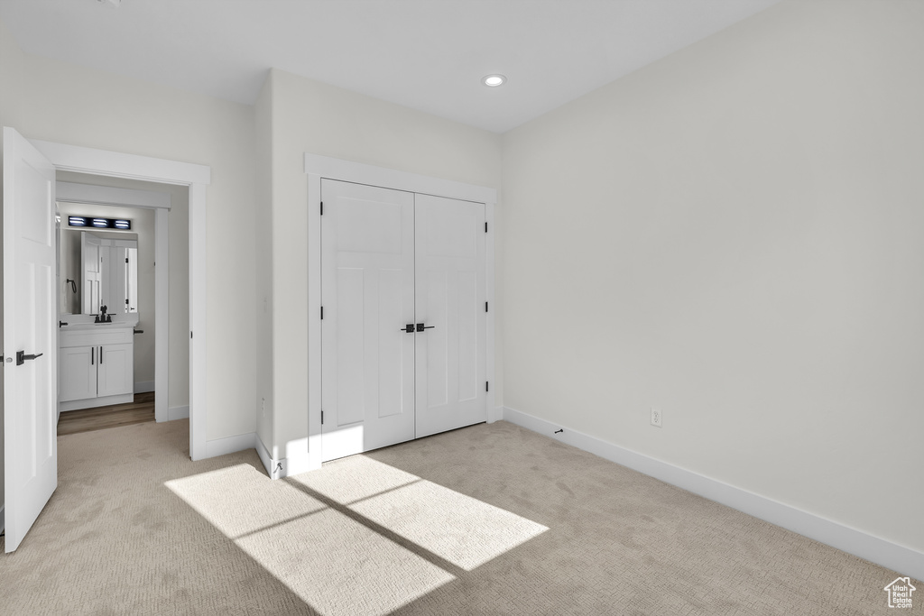 Unfurnished bedroom featuring recessed lighting, a closet, baseboards, and light carpet