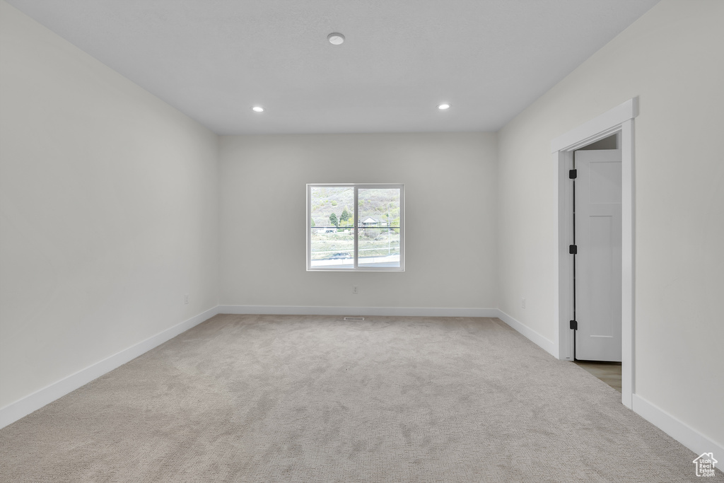 Carpeted empty room featuring recessed lighting and baseboards