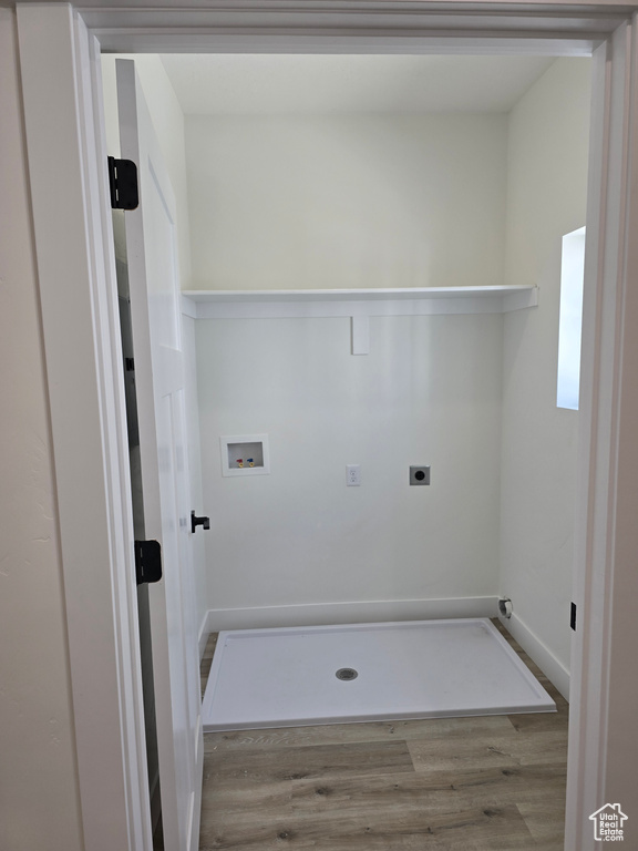 Clothes washing area featuring hookup for a washing machine, hookup for an electric dryer, laundry area, wood finished floors, and baseboards