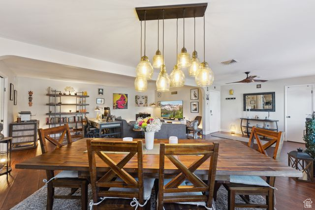 Dining space with dark wood-type flooring and ceiling fan