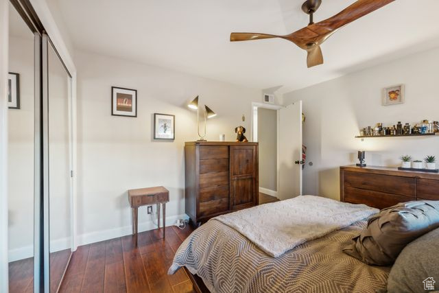 Bedroom featuring dark hardwood / wood-style floors, ceiling fan, and a closet