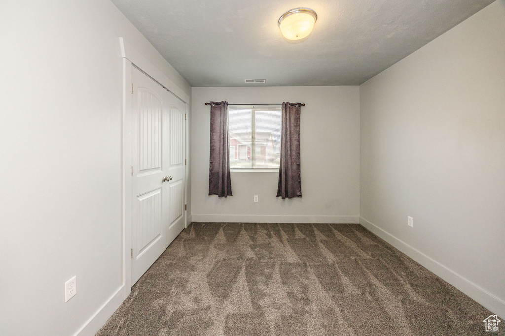 Unfurnished bedroom with carpet and a closet