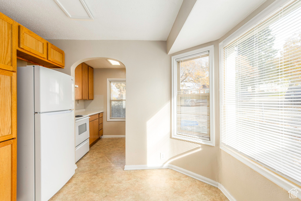 Kitchen featuring white appliances and light carpet