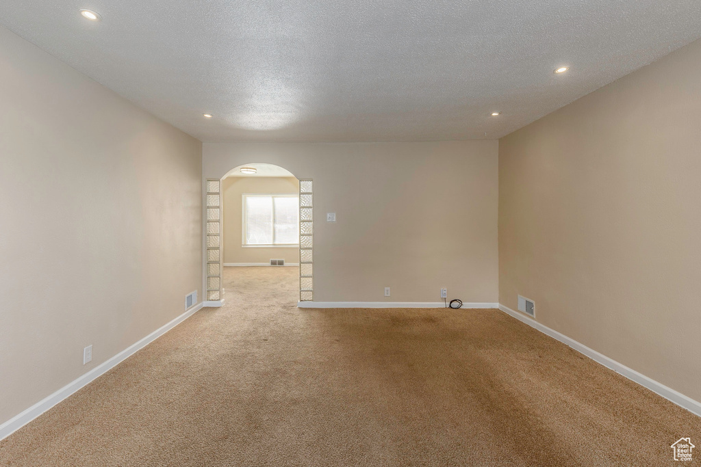 Carpeted spare room with a textured ceiling