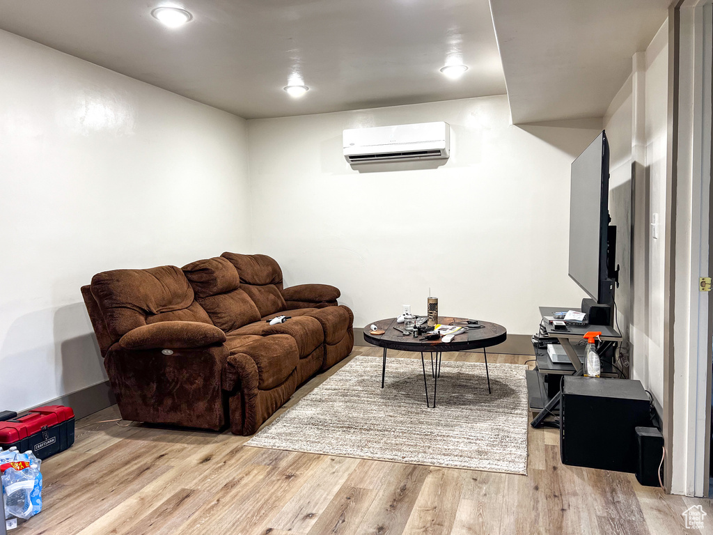 Living room featuring light wood-type flooring and a wall mounted AC