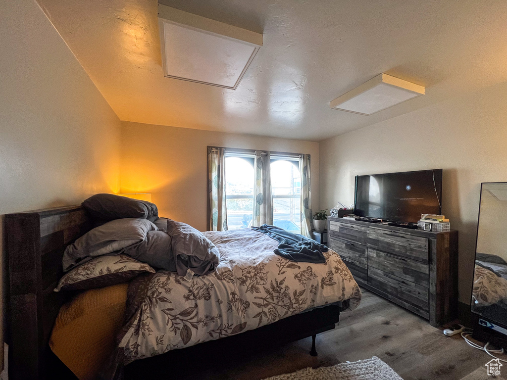 Bedroom featuring light hardwood / wood-style flooring and vaulted ceiling