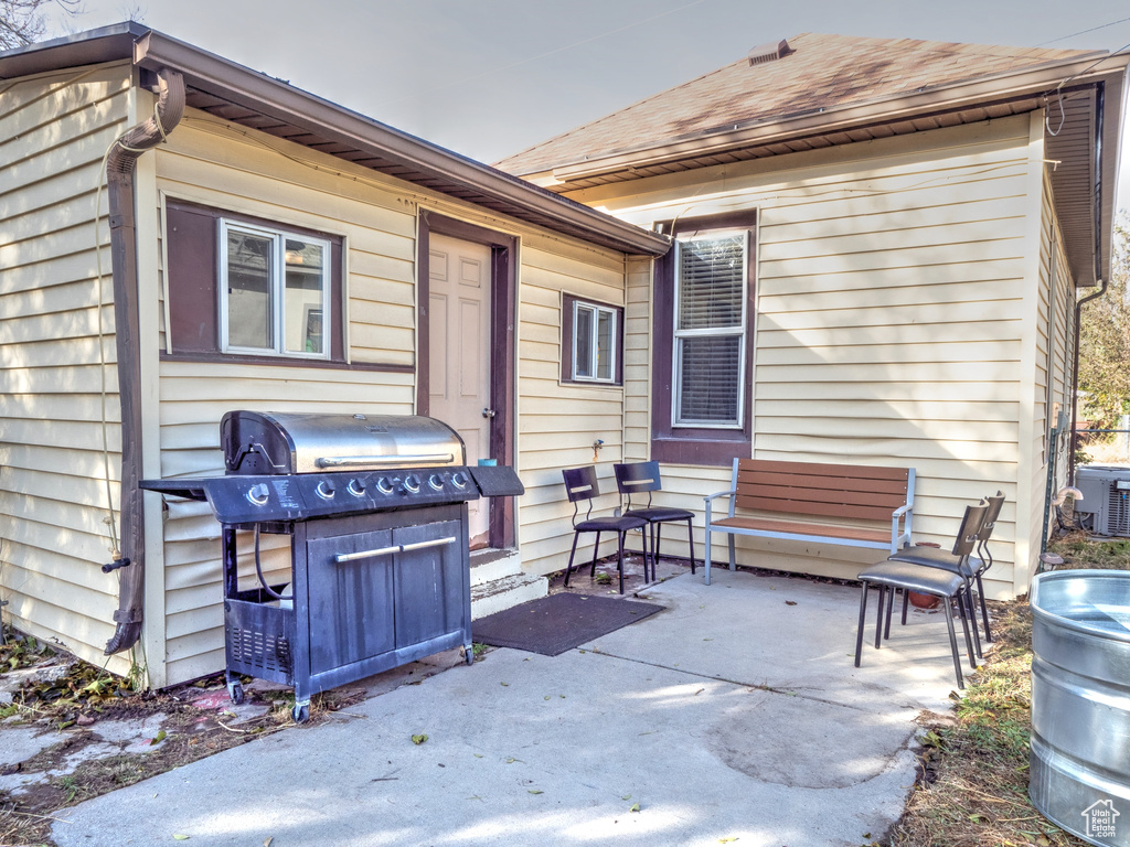 View of patio with central air condition unit and a grill