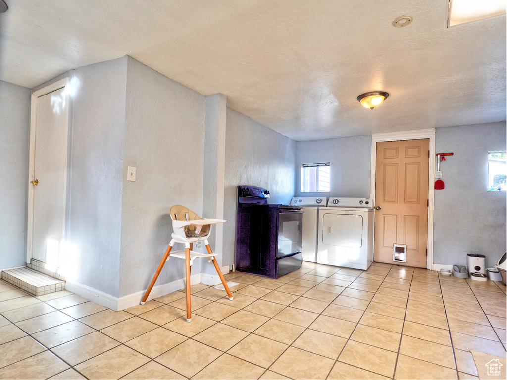 Kitchen featuring separate washer and dryer, a textured ceiling, and light tile patterned floors