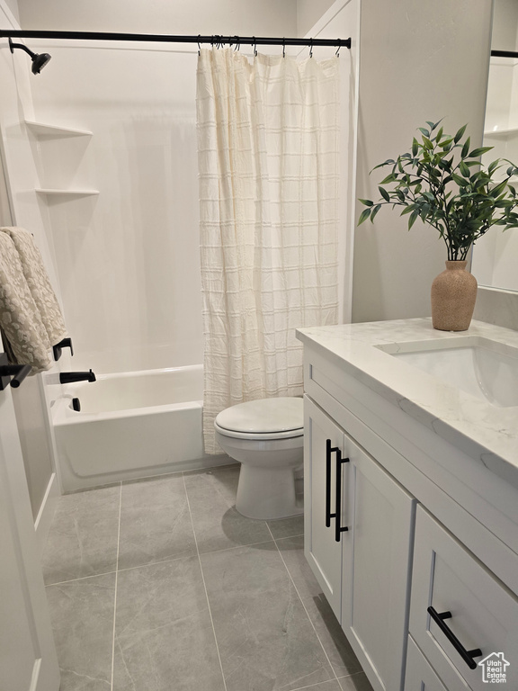 Full bathroom with tile patterned flooring, shower / bath combo, vanity, and toilet