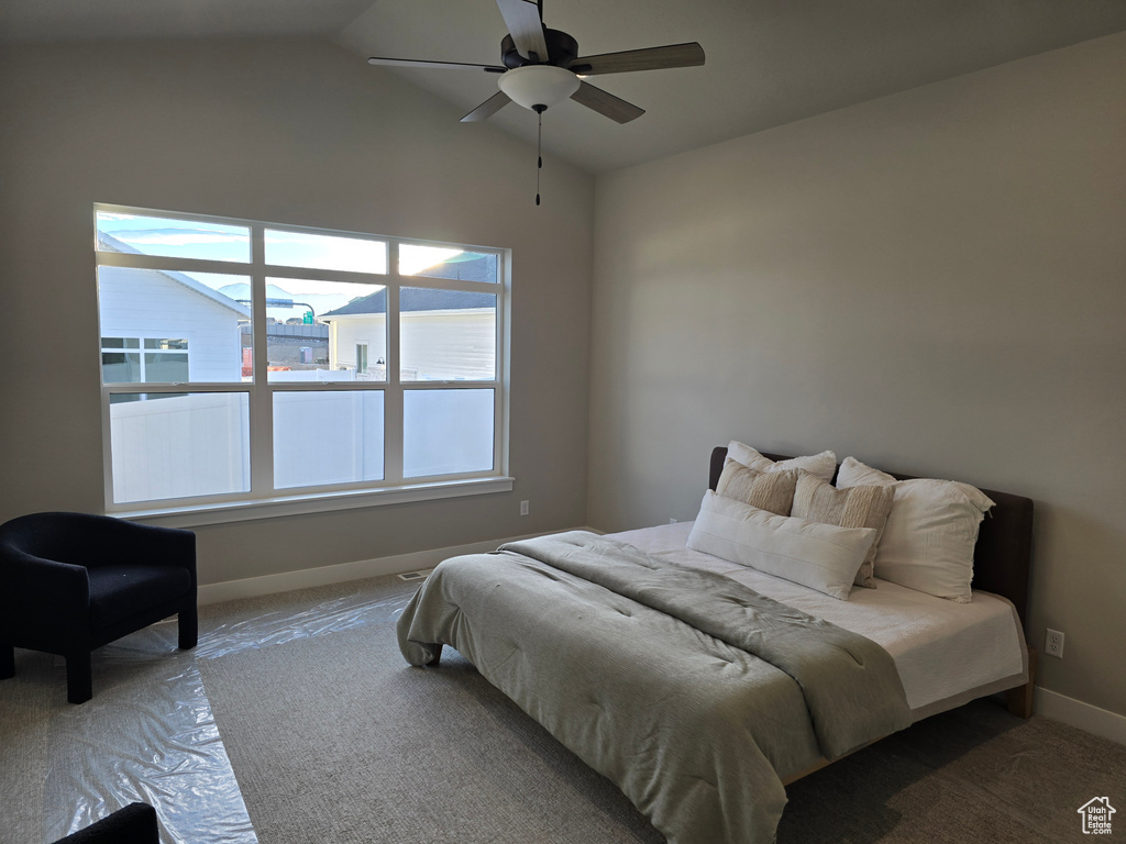 Carpeted bedroom featuring ceiling fan and lofted ceiling
