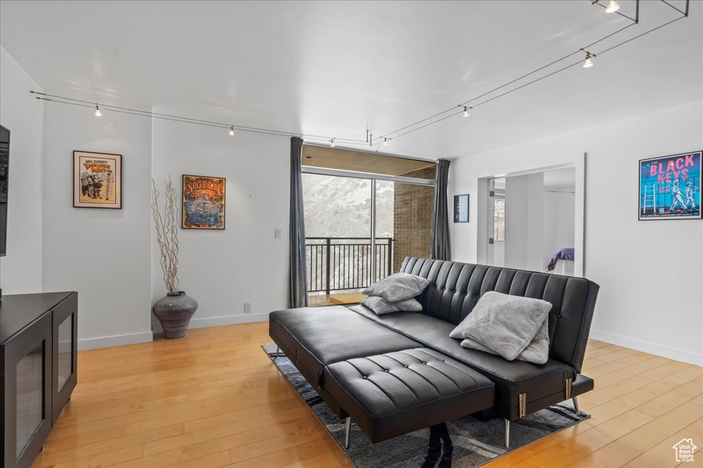 Living room with track lighting and light hardwood / wood-style flooring