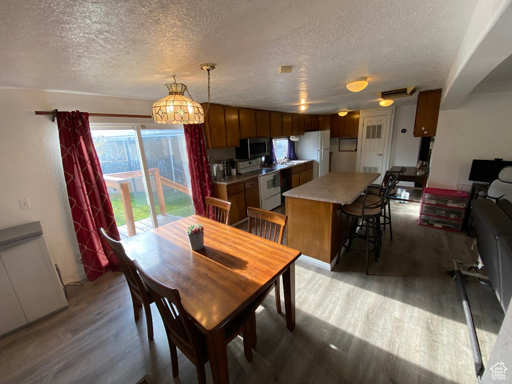 Dining room with hardwood / wood-style floors and a textured ceiling