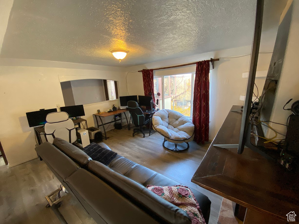 Living room with a textured ceiling and hardwood / wood-style flooring