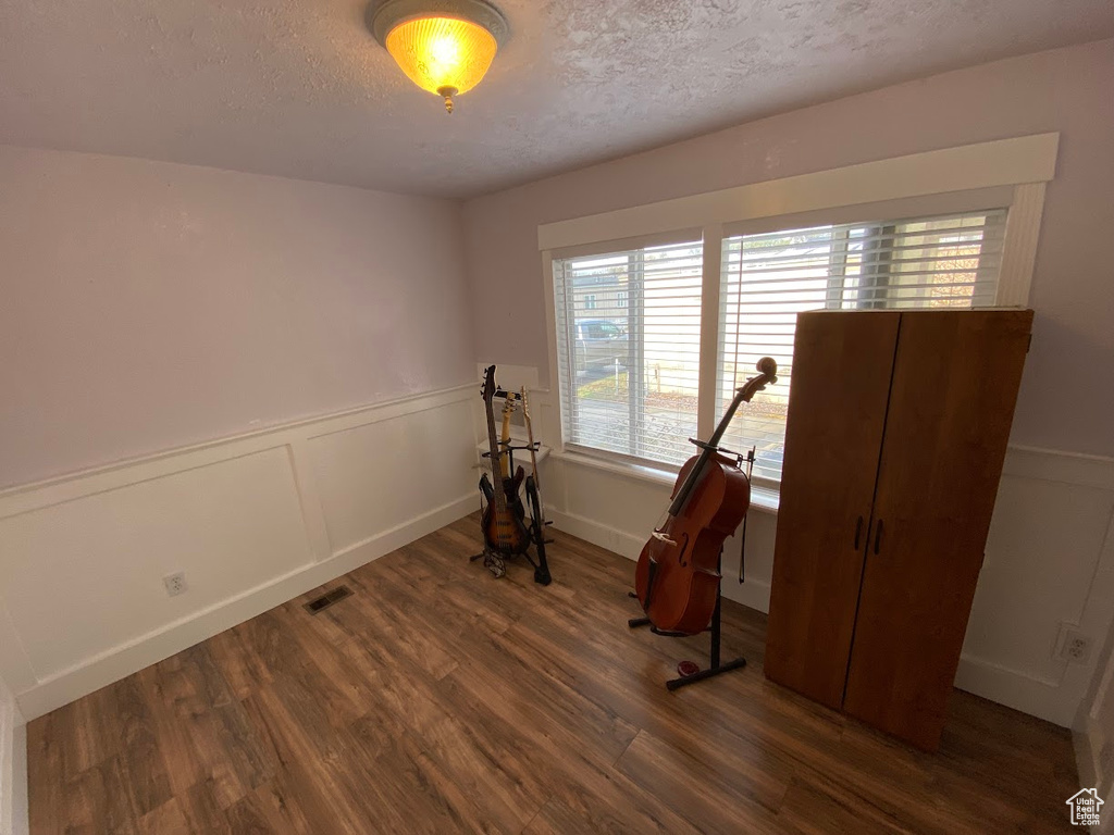 Workout area with a textured ceiling and dark hardwood / wood-style floors