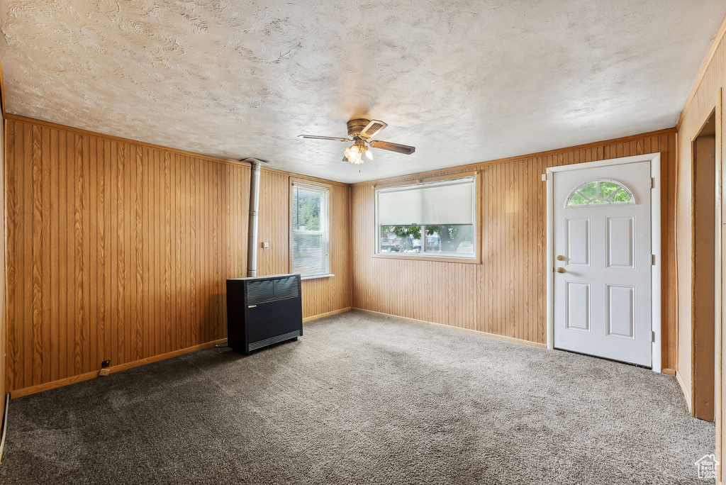 Entryway with carpet floors, a textured ceiling, and ceiling fan