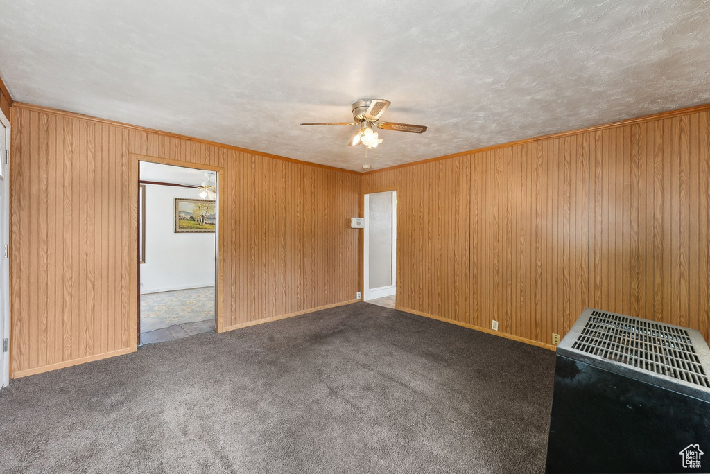 Unfurnished living room featuring ornamental molding, tile patterned floors, and ceiling fan